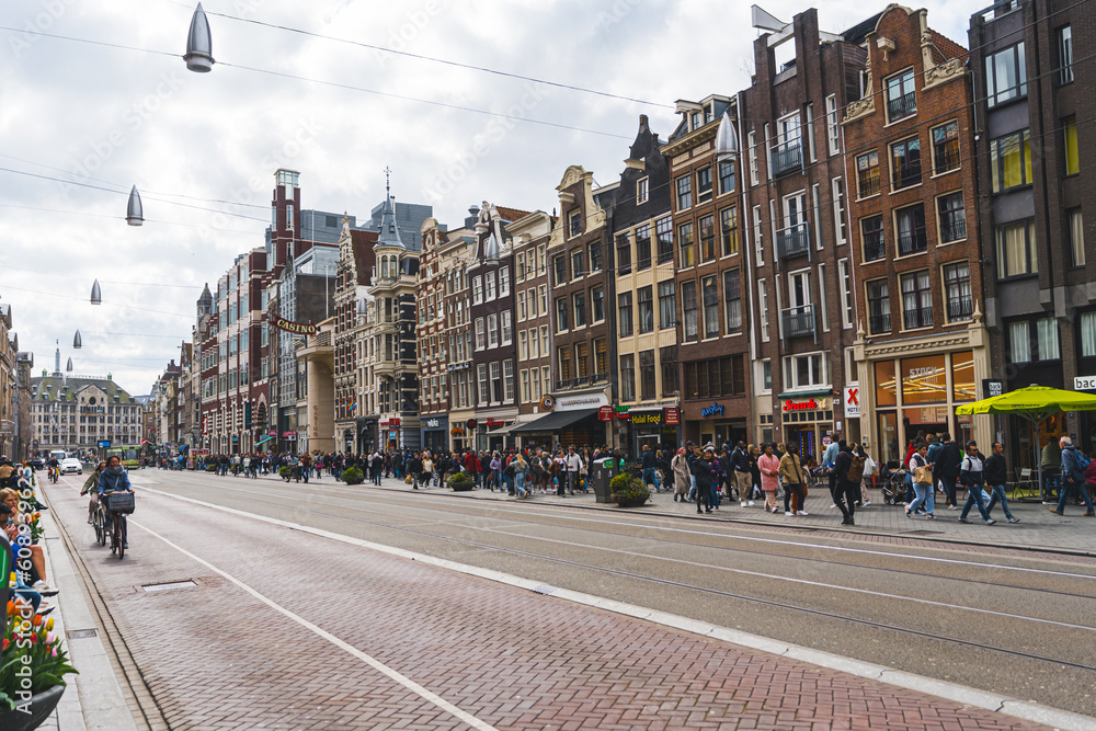 Tram tracks in the middle of Amsterdam street. Beautiful architecture of the capital city of the Netherlands. Transportation concept. High quality photo