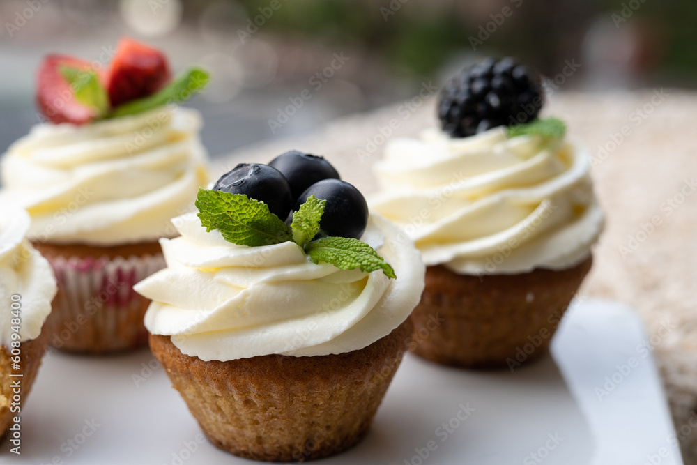 Cupcakes with different fruits on a white plate close-up. Cupcakes with different fruits on a white plate close-up.