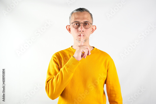 Portrait of Asian Man showing silence, keep silent gesture (shut up)
 photo