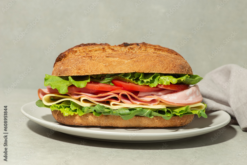 Sandwich with mortadella, cheese and tomatoes on a gray table Sandwich with mortadella, cheese and tomatoes on a gray table