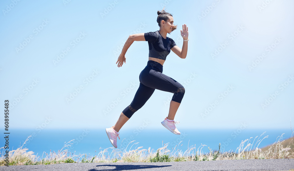 Runner woman, street and jump in nature with speed, fitness and energy for training, wellness and healthy by sea. Girl, running and fast on road for self care, exercise and workout by ocean in summer