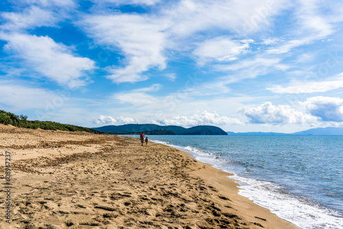 Fototapeta Naklejka Na Ścianę i Meble -  Large and sandy beach in the Rimigliano Park, protected area in the municipality of San Vincenzo, Tuscany region, Italy, with two people in the distance walking