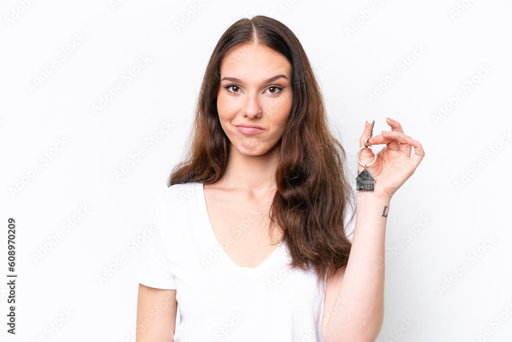 Young caucasian woman holding home keys isolated on white background with sad expression Young caucasian woman holding home keys isolated on white background with sad expression