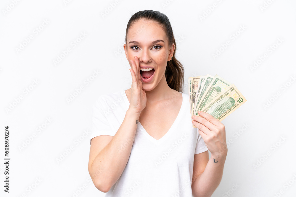 Young caucasian woman taking a lot of money isolated on white background shouting with mouth wide open Young caucasian woman taking a lot of money isolated on white background shouting with mouth wide open