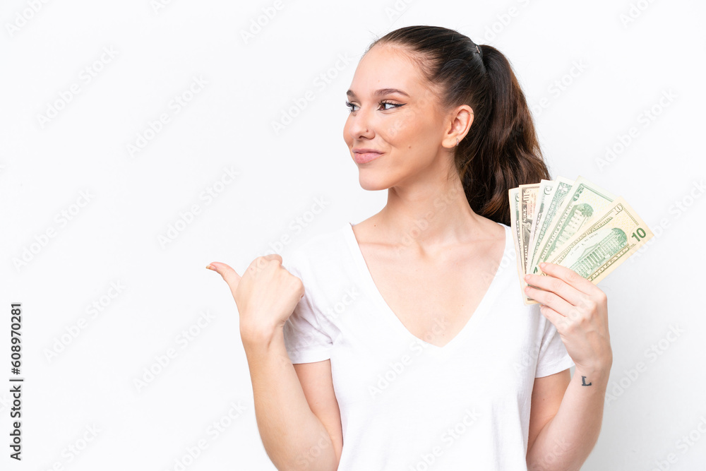Young caucasian woman taking a lot of money isolated on white background pointing to the side to present a product Young caucasian woman taking a lot of money isolated on white background pointing to the side to present a product