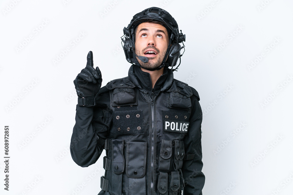 Young caucasian SWAT man isolated on white background pointing up and surprised Young caucasian SWAT man isolated on white background pointing up and surprised