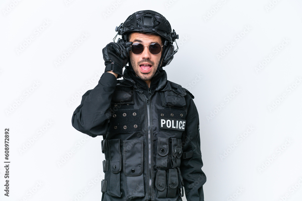 Naklejka premium Young caucasian SWAT man isolated on white background with glasses and surprised