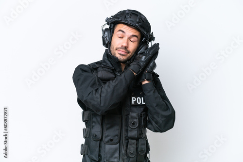 Young caucasian SWAT man isolated on white background making sleep gesture in dorable expression