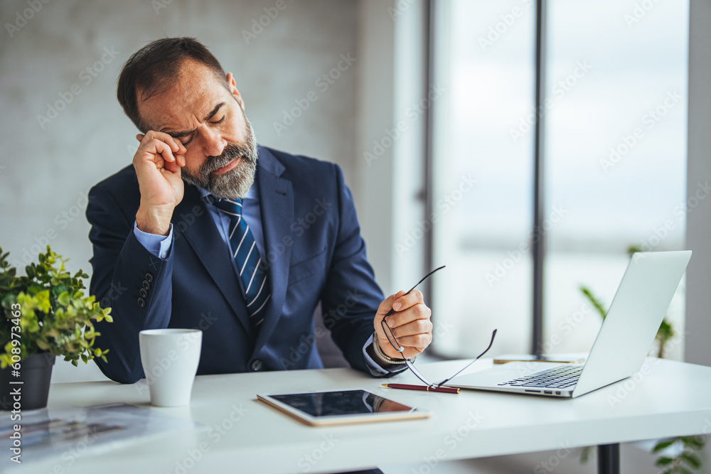 Stressed man in office looking on documents. Business man in office. Business man having problem at work. Tired man feel pain eyestrain holding glasses Stressed man in office looking on documents. Business man in office. Business man having problem at work. Tired man feel pain eyestrain holding glasses