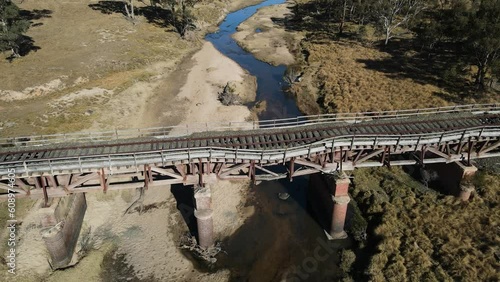 Heritage listed Sunnyside rail bridge spanning over Tenterfield Creek with outback Australian scenic views. Cinematic drone reveal photo