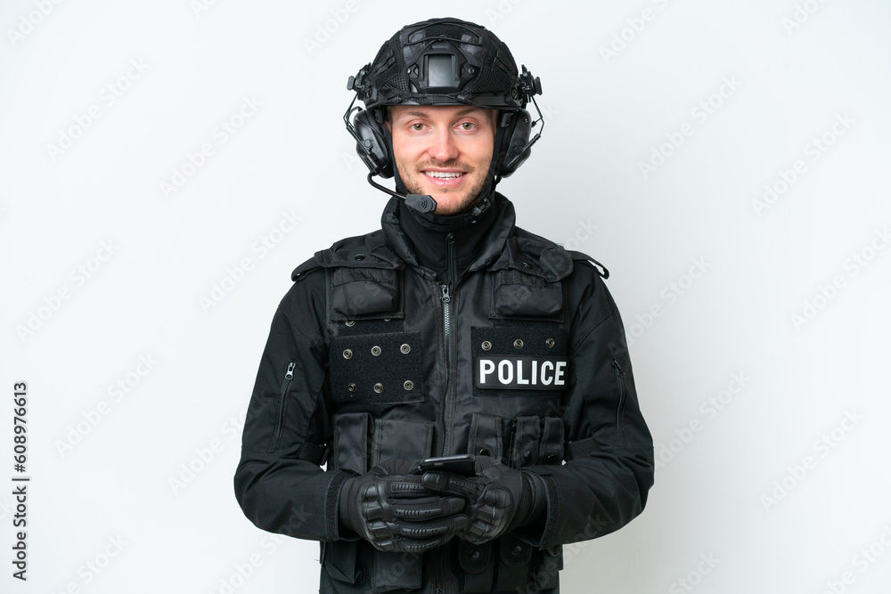 SWAT man over isolated white background sending a message with the mobile SWAT man over isolated white background sending a message with the mobile