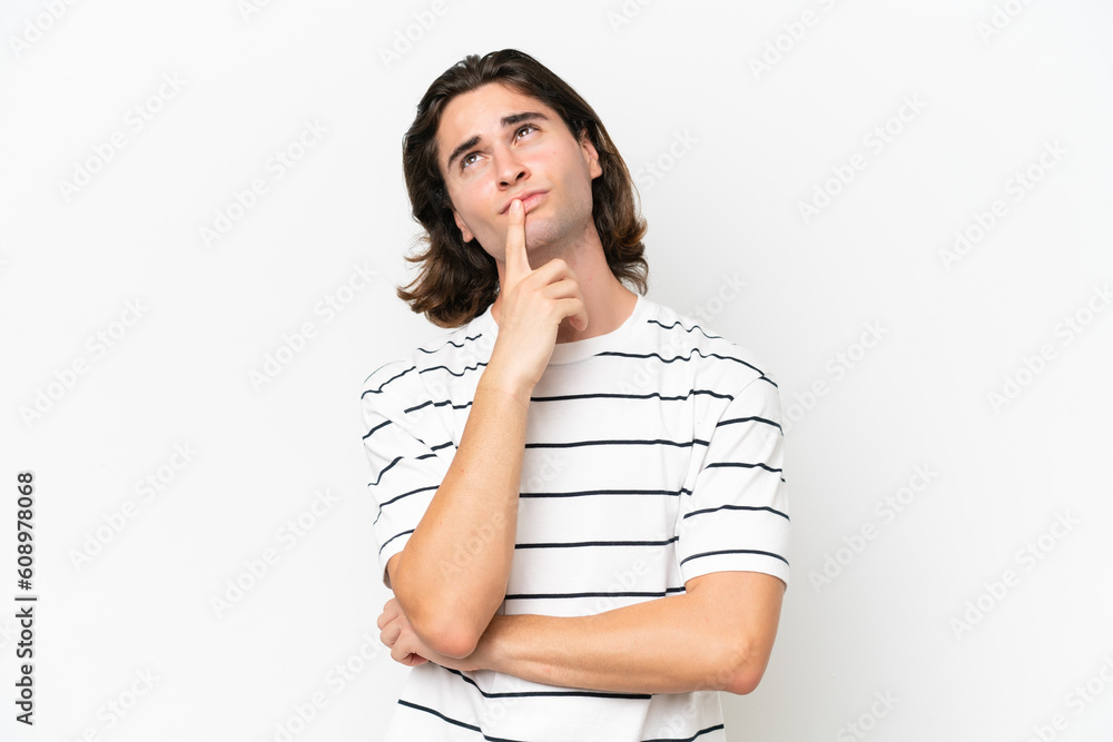 Young handsome man isolated on white background having doubts while looking up