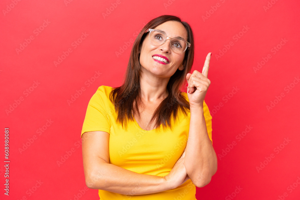 Middle-aged caucasian woman isolated on red background pointing up a great idea Middle-aged caucasian woman isolated on red background pointing up a great idea