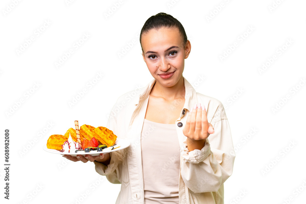 Young Arab woman holding waffles over isolated background inviting to come with hand. Happy that you came Young Arab woman holding waffles over isolated background inviting to come with hand. Happy that you came