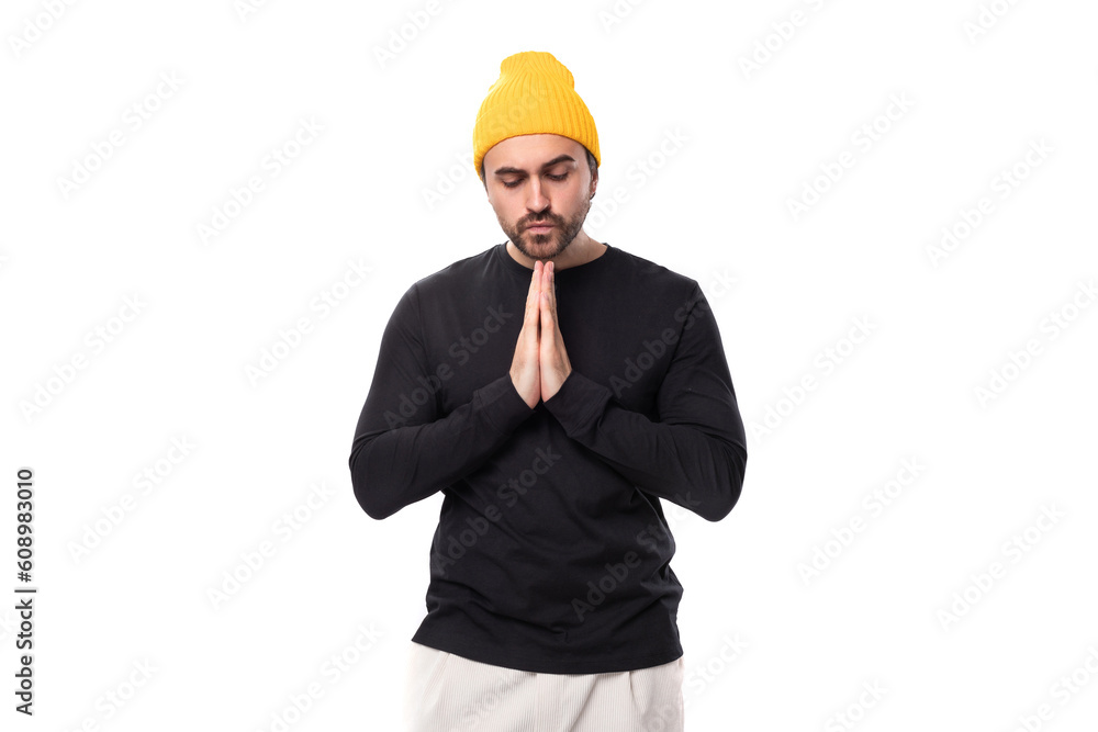young brunette European brutal man in a black jacket prays and hopes young brunette European brutal man in a black jacket prays and hopes