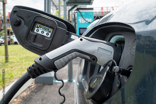 Abastecimento de um carro elétrico com a fonte de alimentação conectada à viatura num posto de serviço para carros elétricos