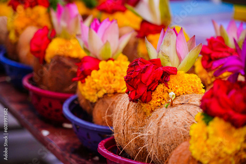 Pealed coconuts, lotus , rose and other flowers prepared for pooja, ritual worship in a temple photo