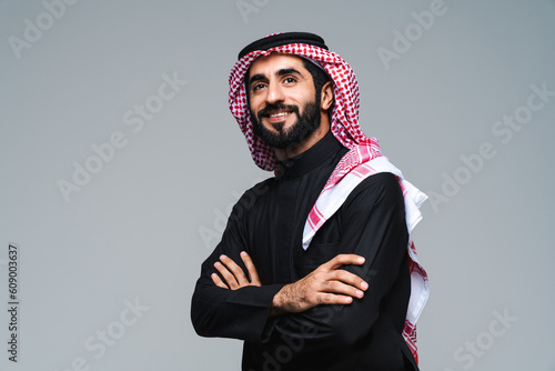 Fotografie Handsome saudi arabian middle-eastern man with traditional thwab portrait in stu