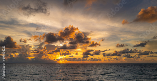 Sunset on sea background. Nature wallpaper with summer sea. Water sea texture. Calm sunrise on tropical sea. Sunshine dawn on ocean water.