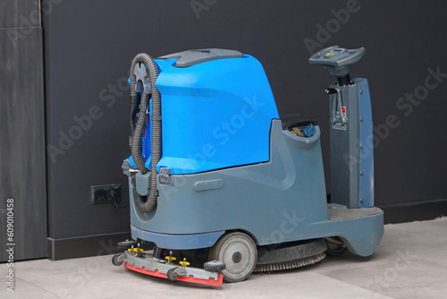 Photography Floor cleaning machine electric floor scrubber stands at shopping mall at the electric point and charging battery
