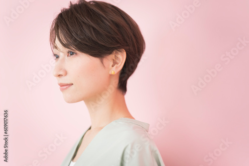 Obraz na płótnie 微笑んでるショートヘアの日本人女性/ピンク背景のビューティーポートレート