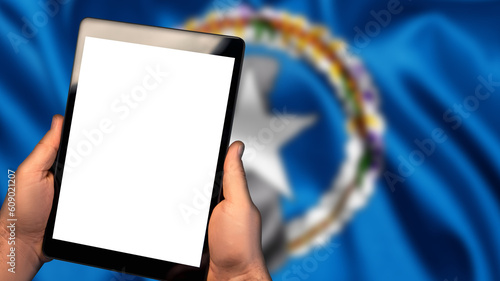 Man hold tablet phone pc gadget with white blank screen, copy space for text, image or message. Flag of Northern Mariana Islands country on background. Technology, information, business
 photo