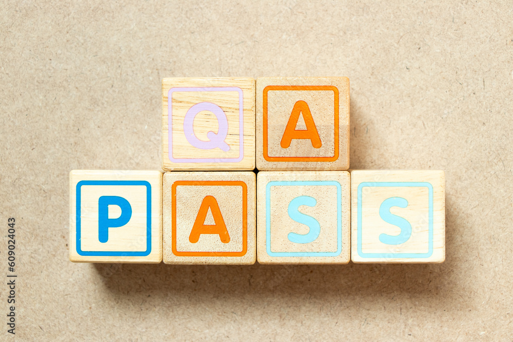 Wooden alphabet letter block in word QA (quality assurance) pass on wood background Wooden alphabet letter block in word QA (quality assurance) pass on wood background