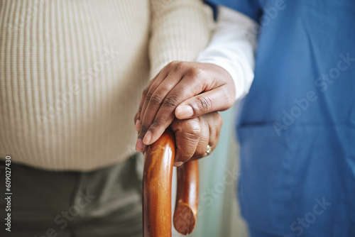 Cane, senior patient and nurse holding hands for support, healthcare and kindness at nursing home. Elderly person and caregiver together for homecare, rehabilitation or help for health in retirement