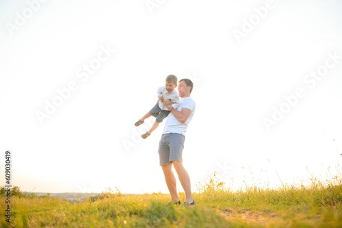 Happy father, son child running playing in the park outdoors together. Family, Father's Day, parenting, active lifestyle concept.