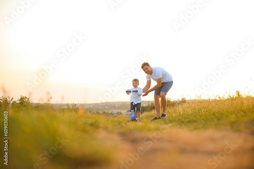 Father help his son ride a bicycle