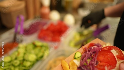 Process of preparing fast food putting salad in a box of fries and vegetables