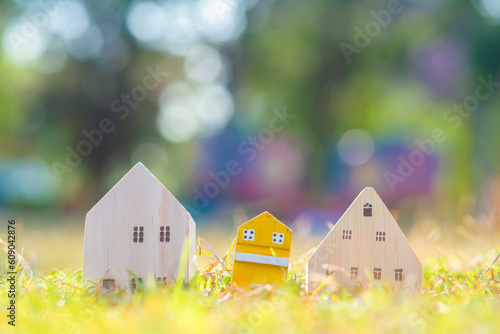 Wooden house model on green grass natire light resident real estate photo