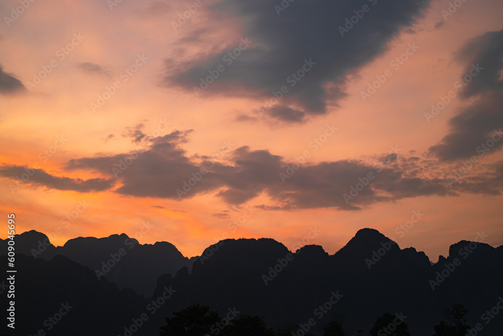 Mountain as the sun sets. Mountain peak green nature scenery. Beautiful sunset over the mountain range at vang vieng.