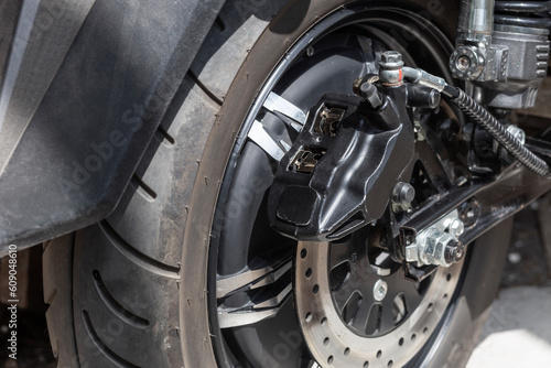 electric motorcycle rear wheel, brake disc and caliper, close up