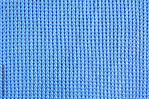 Fragment of blue knitted clothes of rough knitting