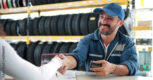 Happy automotive mechanic man in uniform shaking hands with client at auto repair shop. Car service, repair, maintenance, gestures and man mechanic concept