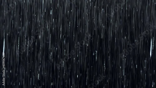 Heavy rain wall falling in front of the camera against black screen in 4k. Raindrops splashing. Rain closeup vfx insert. Practical seamlessly loop-able footage. Rainstorm on black surface.	