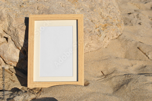 Vertical Wooden frame mockup on summer beach. Ocean vibe. Shell and sand, vacation interior.