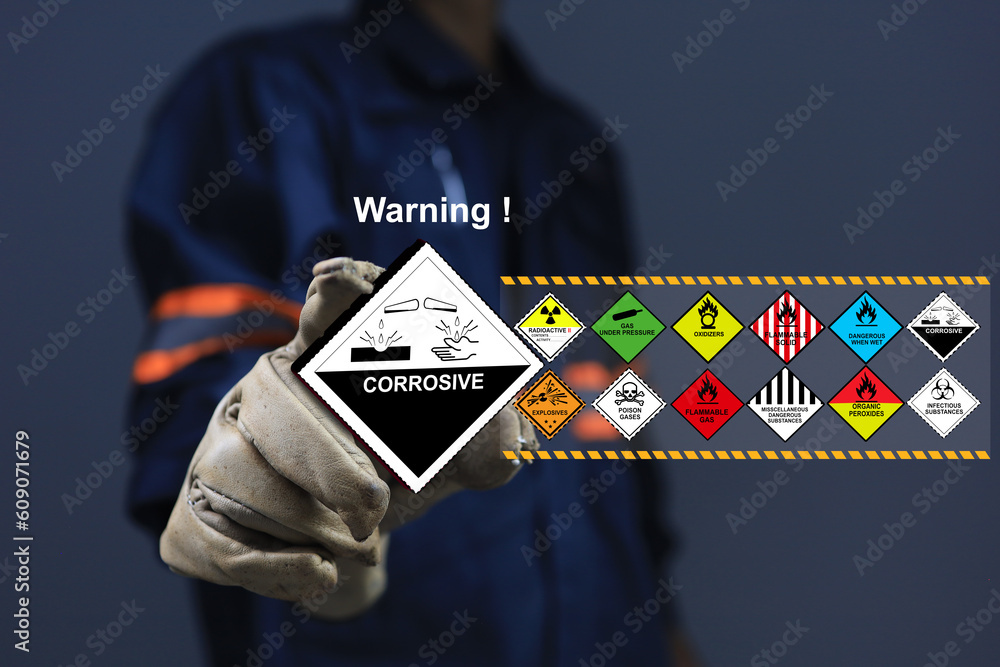 Staff with glove holding the corrosive sign one of dangerous substance
