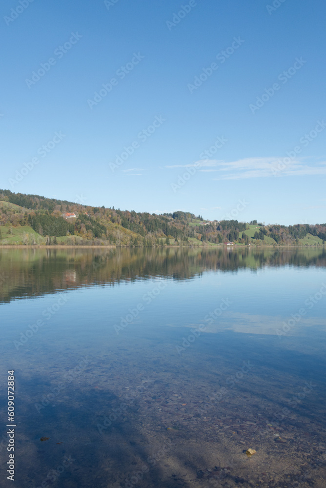 Naklejka premium Landschaften Bayern am See Reflexion Herbststimmung Hügel Buntes Laub Seeoberfläche Spiegelung Natur