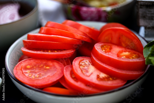 Obraz na plátne Sliced tomatoes laying in the bowl. Red tomato ready to eat.