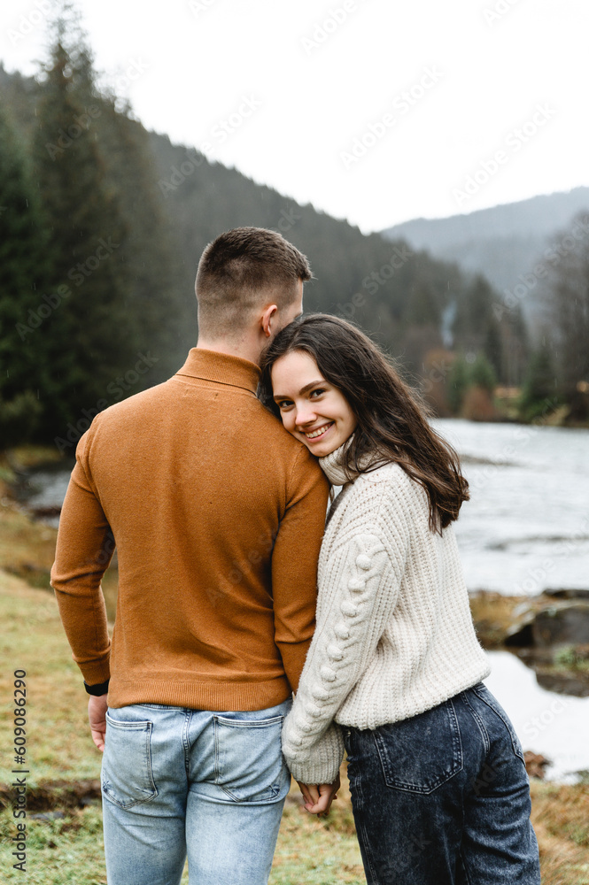 couple outdoors in the autumn season. lovers walk in a mountainous area near the river and forest. pastime of lovers during travel couple outdoors in the autumn season. lovers walk in a mountainous area near the river and forest. pastime of lovers during travel