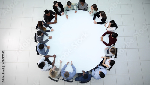 Businesspeople Sitting At Conference Round Table At The Meeting