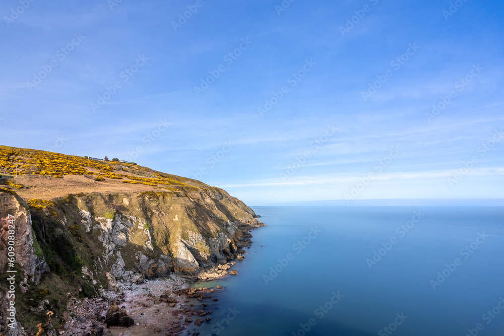 View of green heather fields, the Baily Lighthouse and the Irish Sea seen from the Howth Summit in Howth, near Dublin, Ireland View of green heather fields, the Baily Lighthouse and the Irish Sea seen from the Howth Summit in Howth, near Dublin, Ireland