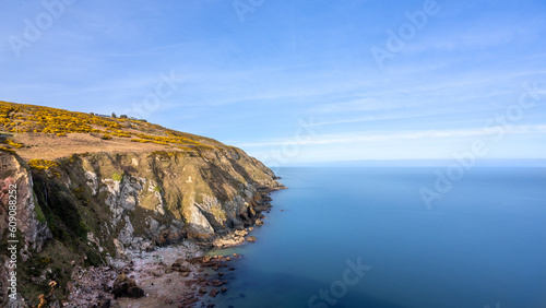 View of green heather fields, the Baily Lighthouse and the Irish Sea seen from the Howth Summit in Howth, near Dublin, Ireland