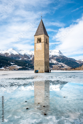 Winter scene at Resia Lake  with sunken gray steeple. Resia Lake is an artificial lake located in the western portion of South Tyrol, Italy, near the Resia Pass.