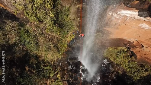 Aérea drone sobre homem fazendo rapel em cachoeira de Brotas, Brasil photo
