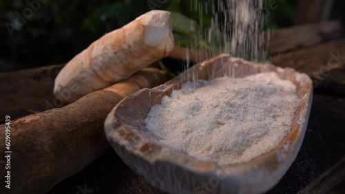 Slow de farinha de mandioca caindo em travessa rústica de madeira photo