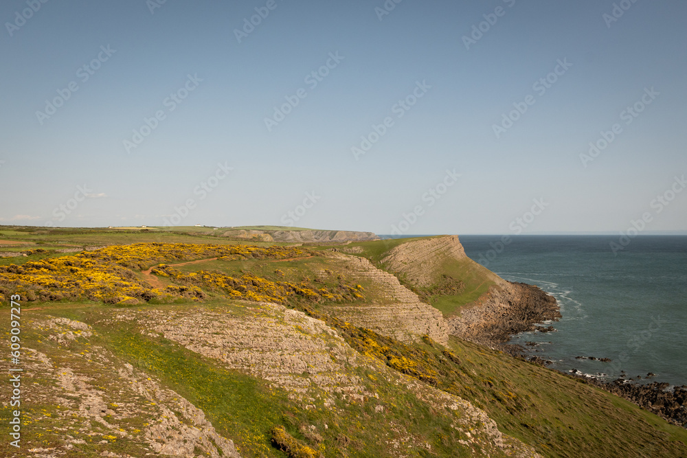 View from the top of worms head looking over the cliff to the sea water on a sunny summer day in South Wales UK on the Gower peninsula. Rugged natural beauty from British outdoor landscape 