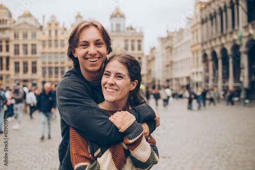 couple standing and hugging in front of a crowded city center in europe grand palace © kristineldridge